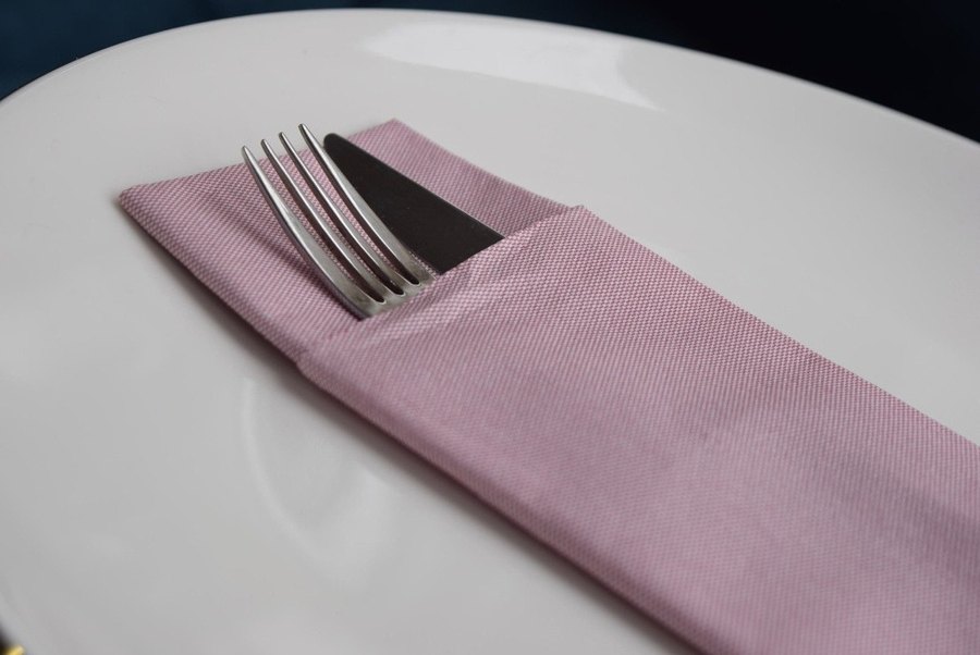 Servilleta tipo tela jean burdeos en montaje de restaurante