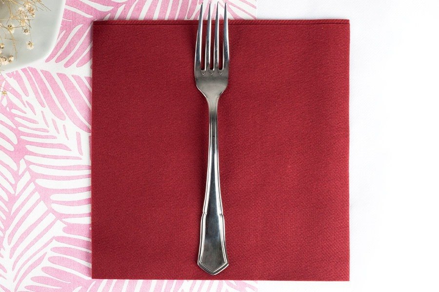 Servilleta tipo tela burdeos en montaje de restaurante